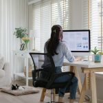 Smart Gen Z tech talent workforce typing SEO sale report on desktop PC happy work easy relax at home office. Remote WFH reskill upskill job MBA study of young people asia woman examine big data graph.